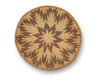 164
A Maidu basket tray
Early 20th century; Northern California
A coiled flat basket with rim ticking and central starburst with irregular zigzag starburst outer band
1.25" H x 11" Dia.
Estimate: $200 - $400