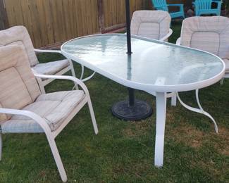 Glass and Metal patio table with 4 matching padded chairs