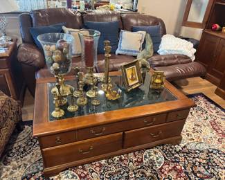 Brass candlesticks. Lounging leather sofa. Coffee table with display drawer