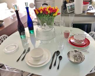 Italian White Glass / Chrome Dining Table by Modani. It revolves and two leaves rise up to make the table seat 6. Glass Cake Dish; Two Sets of China, White & Red; Two Sets of Modern Flatware, Black & Stainless
