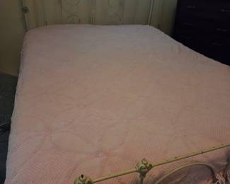 Metal bed with a beautiful pink chenille bedspread