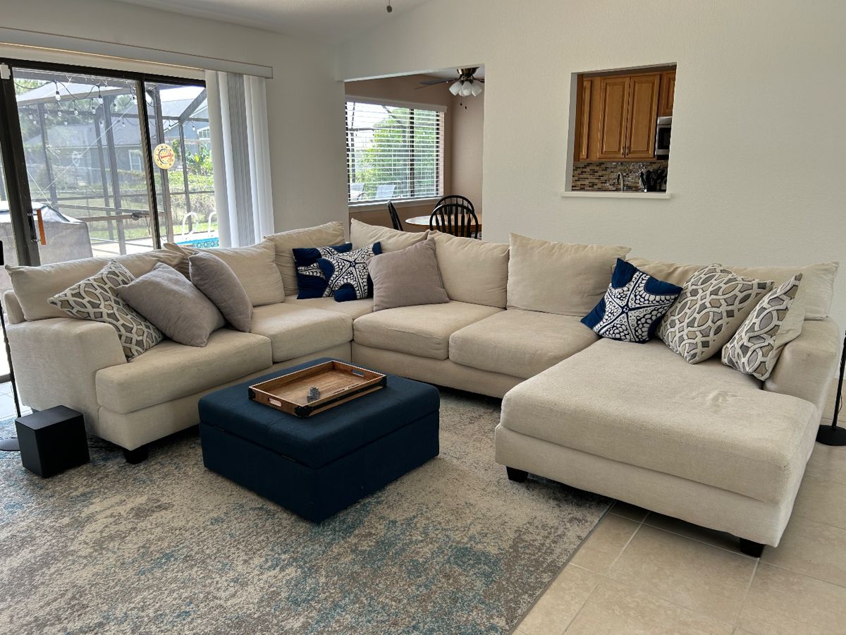 Beige Sectional, Footstool and Rug