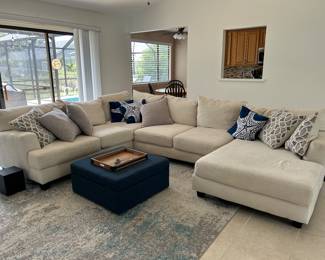 Beige Sectional, Footstool and Rug