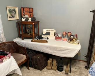 Luggage, sewing and knitting items, and accent tables.