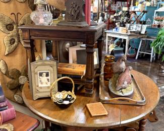 small round table, old childs rocker, globe, vintage bookends, quail in ceramic, retro wall hanging.