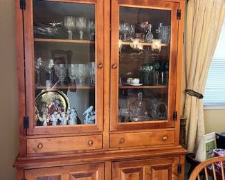 Valuable figurines, crystal, and more in hard rock maple china cabinet and hutch.