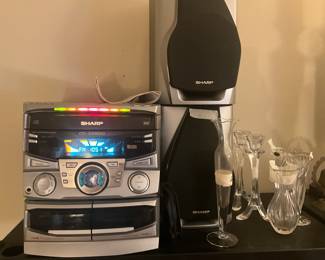 Living room -  Stereo with speakers & table has lots of items