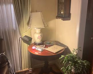 Living room - round vintage table with center drawer - lamp, stand metal lamp, frames and clock on wall to right