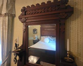 Close up of mirror on dresser with candle holder on dresser