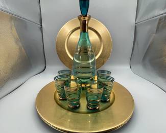 Includes a teal glass decanter with gold accents and six matching shot glasses. The set is styled in a classic 1970s design. Perfect for collectors or special occasions. Included in this set is four gold chargers made of plastic/resin.
See items descriptions and photos for condition details.