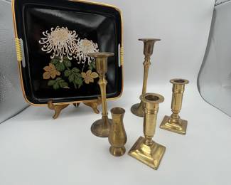 Includes a set of five brass candle holders and a decorative black tray featuring floral designs. The tray is adorned with chrysanthemums and is likely from the mid-20th century. The candle holders vary in height and style, each with unique designs, adding an elegant charm to any decor.
See items descriptions and photos for condition details.