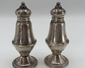 Includes a pair of silver-plated shakers (possibly 20th century), two blue glass shakers (year unknown), and two hand-painted ceramic house-shaped shakers (marked 'Hand Painted Delft' from Netherlands).