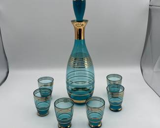 Includes a teal glass decanter with gold accents and six matching shot glasses. The set is styled in a classic 1970s design. Perfect for collectors or special occasions. Included in this set is four gold chargers made of plastic/resin.
See items descriptions and photos for condition details.