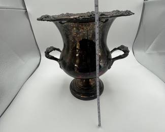 An elegantly designed vintage urn featuring intricate grapevine motifs on the rim and handles. This exquisite piece is crafted from silver-plated material, showcasing a rich patina. Estimated to date from the early 20th century, this urn is perfect for collectors or as a decorative centerpiece.
See items descriptions and photos for condition details.