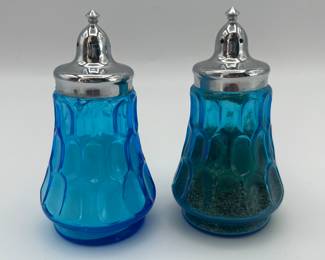 Includes a pair of silver-plated shakers (possibly 20th century), two blue glass shakers (year unknown), and two hand-painted ceramic house-shaped shakers (marked 'Hand Painted Delft' from Netherlands).