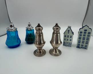 Includes a pair of silver-plated shakers (possibly 20th century), two blue glass shakers (year unknown), and two hand-painted ceramic house-shaped shakers (marked 'Hand Painted Delft' from Netherlands).