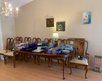 8 seat dining table with chairs, table protector, and a removable leaf!
Covered in dishware and glassware
