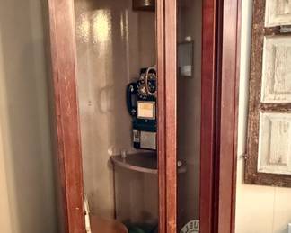 Vintage phone booth dating from the 1950's. Booth is a wooden structure with a glass paneled bi-fold door with original phone, door-activated ventilation fan and overhead light in working condition.