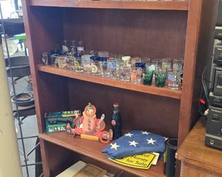 tons of shot glasses and more and a nice bookshelf