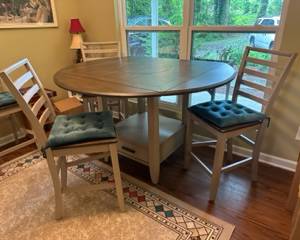 Like-new 42" square high top table converts to 59" round with leaves, 18" Lazy Susan in the middle and 1 storage drawer below. Comes with 4 (24"H) chairs with cushions. $450