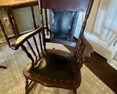 Vintage wooden rocking chair with black leather seat and seat back with bronze nailhead trim; some damage to material on back of seat back otherwise good condition for age; comes with cushions $100