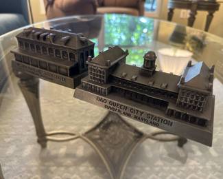 (Far left) A miniature metal replica of the Western Maryland Station Center located in Cumberland, Maryland.
(Far right) A 1974 Banthrico metal coin bank. It is of the train station B & O Queen City Station, Cumberland, Maryland.