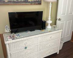 Long white vintage (1980’s) wicker dresser with glass top; signs of wear but typical for its age. All drawers function well. measures 17d x 54 w x 30 h $200