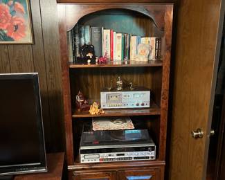 One of three piece hutch displaying books, turn table, cassette player/ tuner, speakers, vintage figurines and loaded with LP’s/45’s in the bottom cupboard.