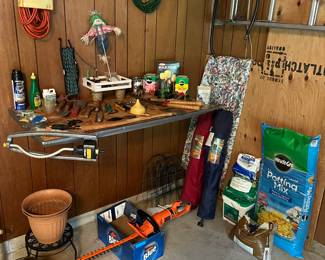 Elec. Bush trimmer, plant stand, folding chairs in bags, potting soil, grass seed, bird food, sand, ext. cords, lawn sprinkler, miracle grow, garden tools and hose accessories.