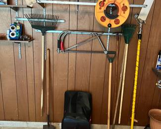 Metal gas can, garden rakes and shovels, bow saws and ext cord.