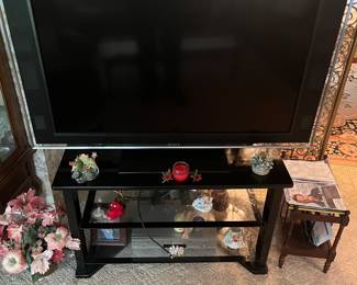 SONY 55” flat screen TV mounted on a 3 tier glass shelf.