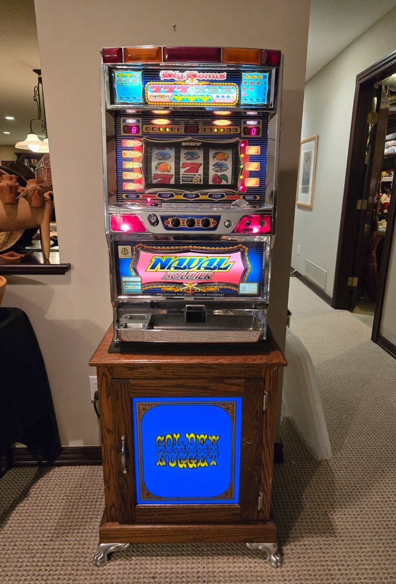 Slot machine on lighted cabinet w/tokens