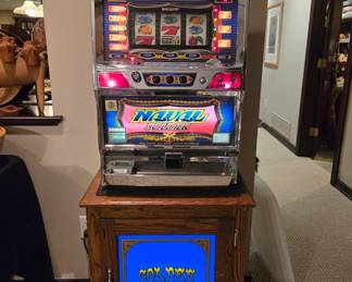 Slot machine on lighted cabinet w/tokens