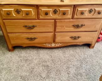 Guardsman Light color wooden dresser with seven drawers featuring decorative hardware and curved edges