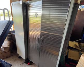 3 cabinets on wheels, large industrial shelving behind