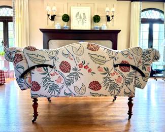 SOLD; custom upholstered designer love seat with camel back, black corner braces, and large botanical design; 73x31x37