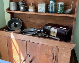 Primitive Rustic cabinet loaded with vintage treasures that include bottles of marbles, radio, cake pan, wooden butter mold and more