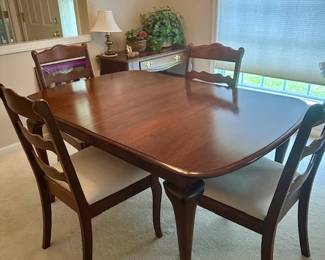 Queen Anne style solid cherry formal dining table with 2 armchairs and 4 chairs (newly upholstered). Also has 2 leaves and table pads.