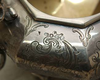 Closeup of hallmarks on the 19th century English sterling silver teapot, coffee pot, creamer, and sugar bowl