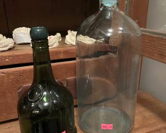 Antique glass bottles - a dark green mallet shaped bottle and a clear glass stoppered bottle
