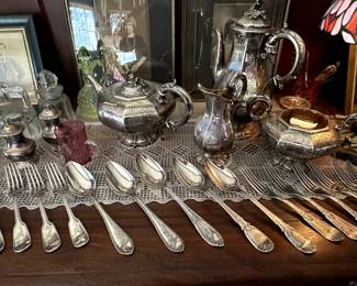 A 19th century English sterling silver teapot, coffee pot, creamer, and sugar bowl; also shown are a pair of silver plated salt and pepper shakers, and a selection of silver forks and spoons