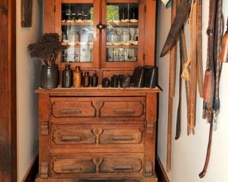 A 19th century handmade Eastlake spoon carved style two-piece cupboard, a collection of antique early American glass bottles including such Kalamazoo Bottling Co., and medical curatives as Dr. Kennedy's Medical Discovery, Roxbury Massachusetts; Dr. Kilmers Swamp Root Kidney Liver & Bladder Cure; a collection of vintage metal cowbells, glazed stoneware bottles, antique medical and dental tools, dental casts, stoneware jars, vintage glass medicine/chemical bottles