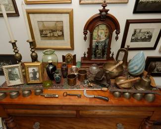 Antique William L. Gilbert Jupiter mantle clock, antique brass sleigh bells, vintage brass candlestick holders, vintage opalescent swirl glass lampshade, 19th century cast iron fluting pleating iron with hand roller, antique military bugle, framed antique photographs, vintage Tibetan brass singing bowls, hoof pick, vintage uranium glass vase and uranium glass flower frog; large brass bell with wooden handle
