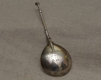 Reverse view of antique sterling silver horse hoof end spoon, probably 17th century Dutch. Tapering stem and shaped junction to the bowl, reverse of bowl with rat-tail; tulip maker's mark / hallmark stamp; initials GH and SH, design of a shield bearing coat of arms suspended by stylized branch or log. 