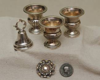 Antique silver urn form toothpick holders, a silver dinner bell, antique silver coin, silver brooch