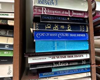 Two shelves of books on Judaism - Titles include The High Walls of Jerusalem, Encyclopedia of Jewish Concepts, Ancient Israel Myths & Legends, The Springs of Jewish Life, A Handbook for the Jewish Family, Diaspora, Coat of Many Colors, A Collector's Guide to Judaica, A Dictionary of Yiddish Slang & Idioms, New York Jews And The Quest for Community, and many more books
