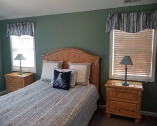 Full bedroom suite with matching nightstands; table lamps; window treatments