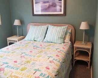 Queen bed with wicker headboard; matching wicker end tables; table lamps