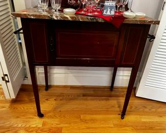 Antique cabinet with marble top and bronze towel racks on casters