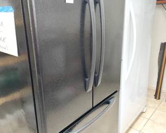 Black Amana French Door refrigerator with freezer below (35.5"W x 31"D x 69"H) and Upright White Frigidaire Freezer (32"W x 28.5"D x 70"H)